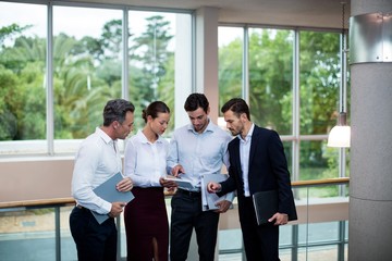 Obraz premium Business executives discussing over digital tablet