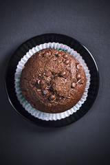 Chocolate muffin on a dark table, view from top
