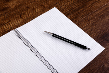 Notepad with pen on the wooden rustic desk. Mockup concept with empty notebook page. Mock-up of blank diary. Wooden rustic desk.