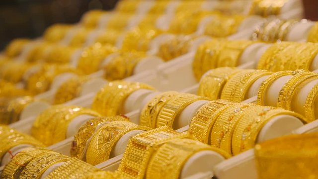 Gold bracelets on the market in Dubai. Eastern Market with gold ornaments. Golden Arab market in the UAE. gold market. Showcase with gold bracelets. Jewelry store: shelves.
