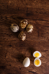 Quail eggs. Raw and boiled sliced food. Natural organic eco eggs. Wooden rustic background.