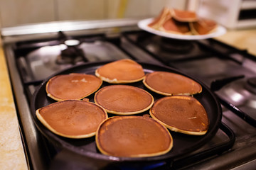 Making pancakes in a black pan. Shrovetide, pancake week