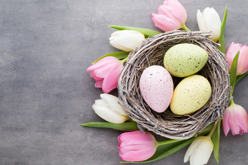 Obraz na płótnie Canvas Easter eggs in the nest on a gray background. Spring greeting ca