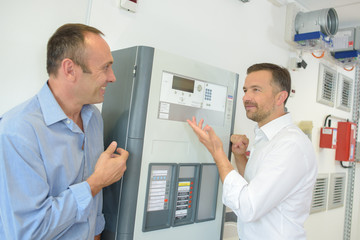 Men looking at electrical equipment