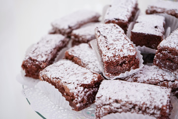 Brownie with glazed sugar in the top, on a white table on a white background.