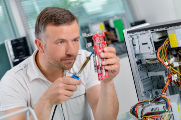 Fototapeta na wymiar Computer specialist repairing a printed circuit