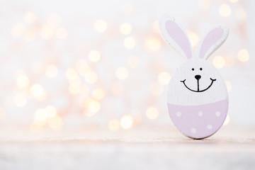Wooden easter rabbits on the bokeh background.