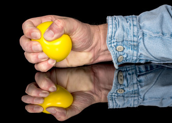 Man squeezes a yellow stress ball