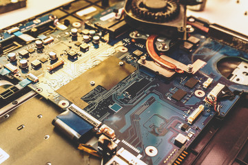 Disassembled laptop. Printed Circuit Board with many electrical components. 