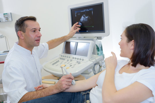 Doctor scanning patient's arm and discussing results