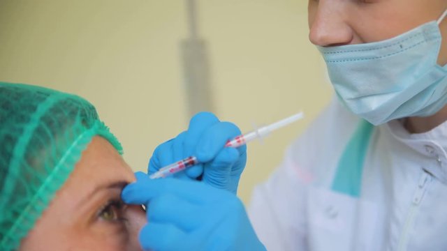 Cosmetology doctor female makes botox medicine injection to her patient in medical clinic