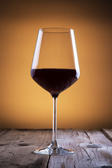 Elegant glass of red wine on wooden table