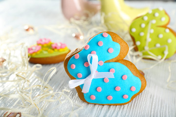 Creative rabbit shape Easter cookie and decorations on wooden table, closeup