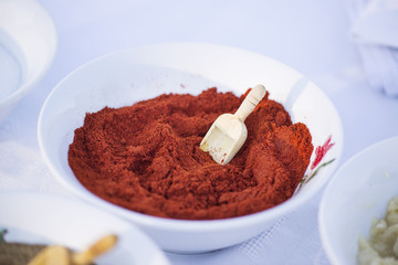 Red pepper powder in white bowl, close up