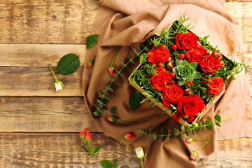 Fototapeta na wymiar Beautiful flowers in gift box on wooden background