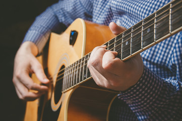 Fototapeta premium Close up of guitarist hand playing guitar