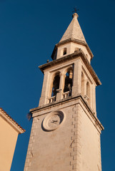 Fototapeta premium Ancient orthodox church bell tower in Budva old town with deep blue sky in the background