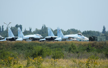 Military airfield and parking lots of planes.