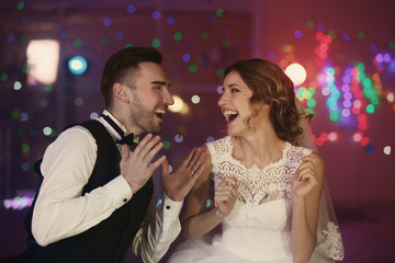 Cute happy wedding couple against defocused lights