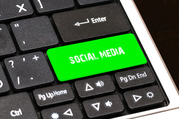 On the laptop keyboard the green button written SOCIAL MEDIA