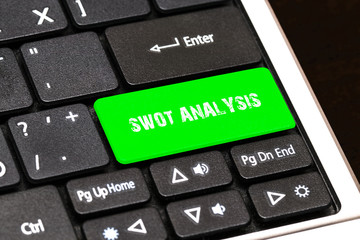 On the laptop keyboard the green button written SWOT ANALYSIS