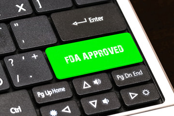 On the laptop keyboard the green button written FDA APPROVED