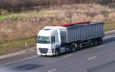 White lorry with tipping trailer in motion on the motorway