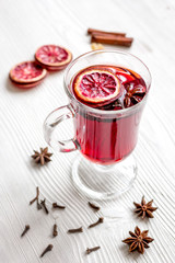 mulled wine with spices in cup on wooden background