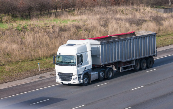 White Lorry With Tipping Trailer In Motion On The Motorway