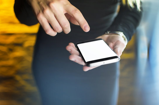 Modern top view of black smartphone. Women touching blank screen with finger. Empty display for adding interface. Business and technology concept. 