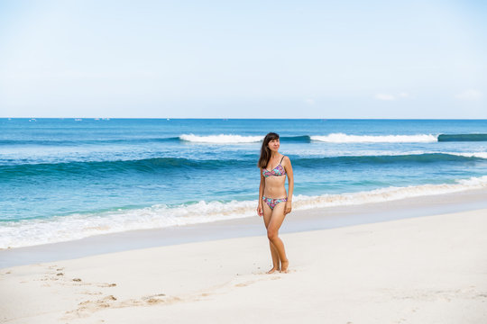 Beautiful woman in bikini. Young and sporty girl on a tropical beach.
