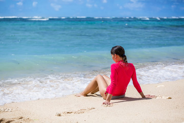 Fototapeta na wymiar Beautiful girl on the beach. Tropical ocean. Pink swimsuit