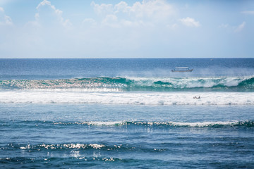 Blue waves in Bali. Tropical surfing. Relax in tropics. Sunny day in paradise