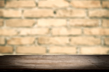 Dark wooden desk and brick wall. Mock up for display of products