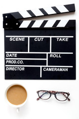 Screenwriter desktop with movie clapper board white background top view