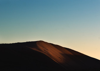 Fototapeta na wymiar First sun rays on the sand dunes