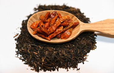 red dried goji berry fruit on decorative wooden spoon on white background close up