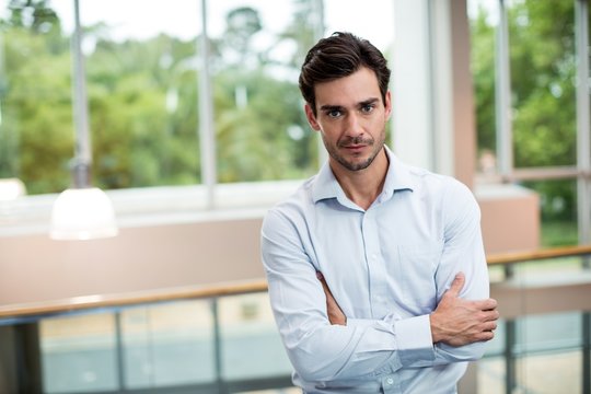 Male business executive with arms crossed at conference center