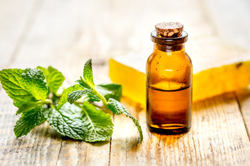 organic cosmetics with herbal extracts of mint on wooden background