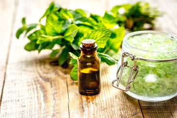 organic cosmetics with herbal extracts of mint on wooden background