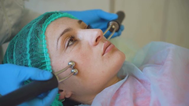 Cosmetology doctor female makes treatment procedure her patient in medical center closeup