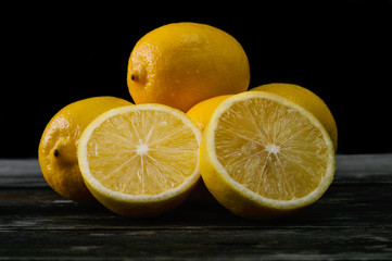 Fresh lemons on an old wooden table. Selective focus and small depth of field.