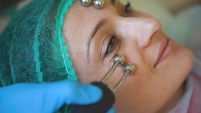 Cosmetology doctor female makes treatment procedure her patient in medical center closeup