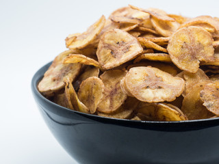 Sweet bananas chip in black bowl isolated on white background. S
