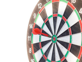 Red dart arrow hitting on center target of dartboard, filter color effect.
