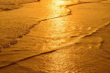 Surface of water on the beach in the sunset time.