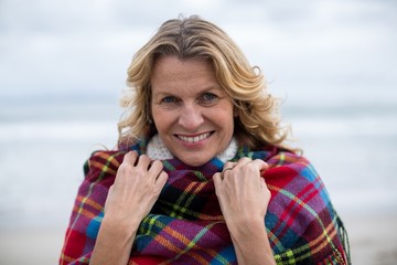 Mature woman wrapped in shawl on the beach