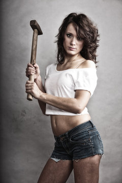 Sexy girl repairman holding hammer tool