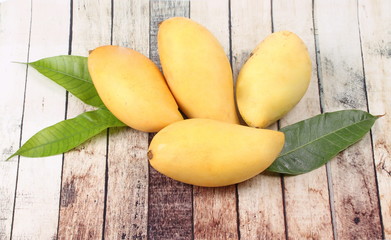 Ripe golden mangos with leaf .