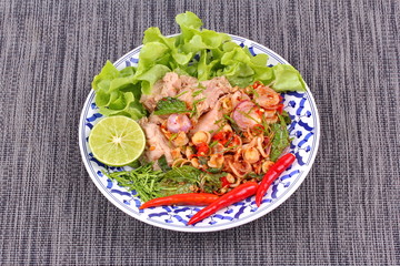 Spicy and sour mixed herb salad with tuna served .